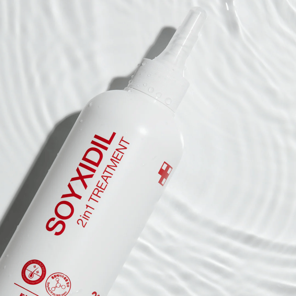 Bottiglia di Medicube Soyxidil 2in1 Treatment si trova su una superficie d'acqua ondulata, simboleggiando cura idratante e rinfrescante.