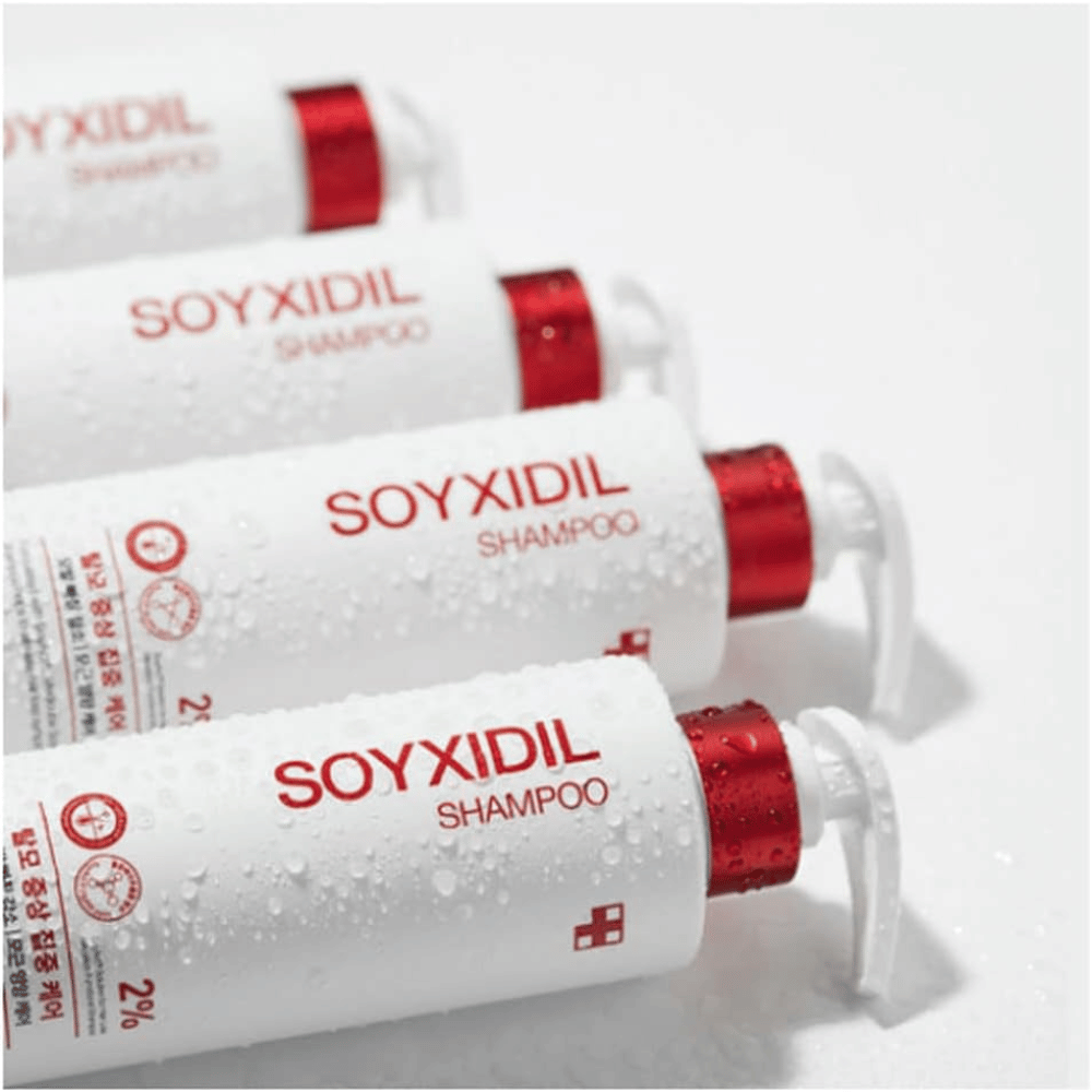 Diverse bottiglie di Medicube Soyxidil Shampoo disposte in fila con gocce d'acqua - mostra la sensazione fresca e curativa del prodotto.