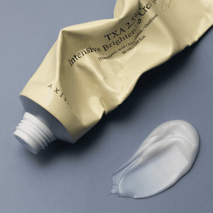 Immagine del prodotto con il tubetto e una noce di crema accanto per mostrare la consistenza morbida e cremosa e la formula idratante. Il focus è sul glow e sull’applicazione uniforme.
