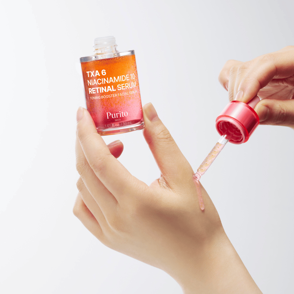 Mano applica Purito TXA 6 Niacinamide 10 Retinal Serum. Formula leggera con ingredienti attivi per luminosità, elasticità e pelle più chiara.