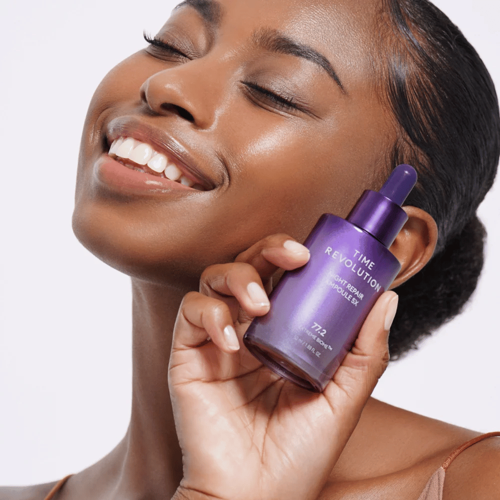 4. MISSHA Time Revolution Night Repair Ampoule 5X – modella tiene in mano un siero notte viola per la cura del viso e la luminosità