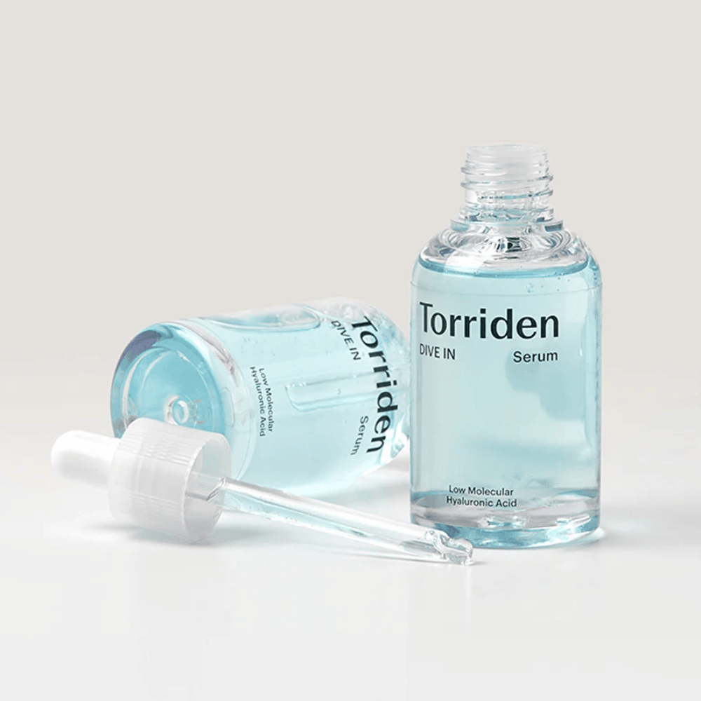 Una bottiglia di Torridens DIVE-IN Low Molecule Hyaluronic Acid Serum 50ml accanto a una bottiglia d'acqua, che enfatizza il siero di acido ialuronico e l'idratazione.