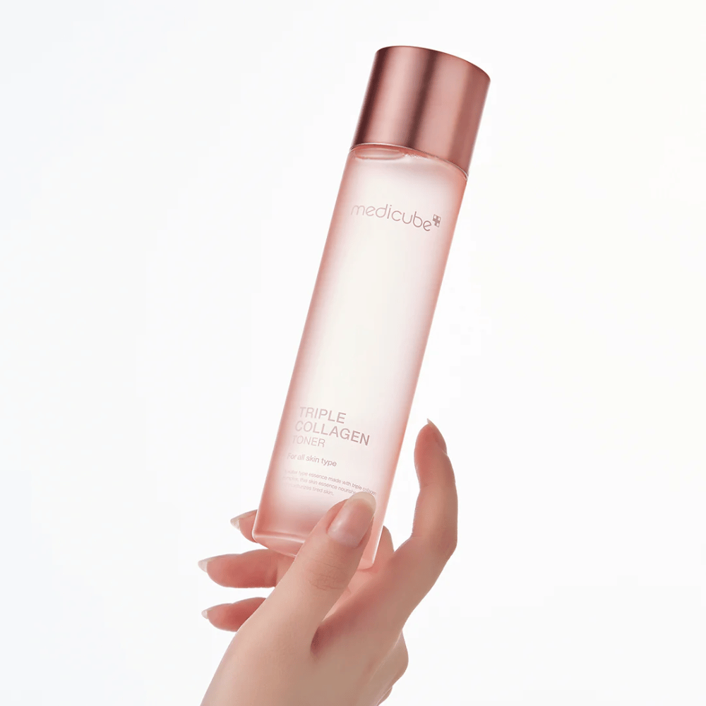 Mano che tiene una bottiglia rosa di Medicube Triple Collagen Tonico viso 4.0, un tonico viso idratante e rassodante per tutti i tipi di pelle.