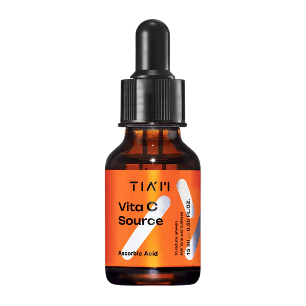 TIA'M Vita C Source, un siero con acido ascorbico in una bottiglia di vetro marrone con pipetta nera ed etichetta arancione – efficace per illuminare la pelle e ridurre il tono della pelle irregolare.