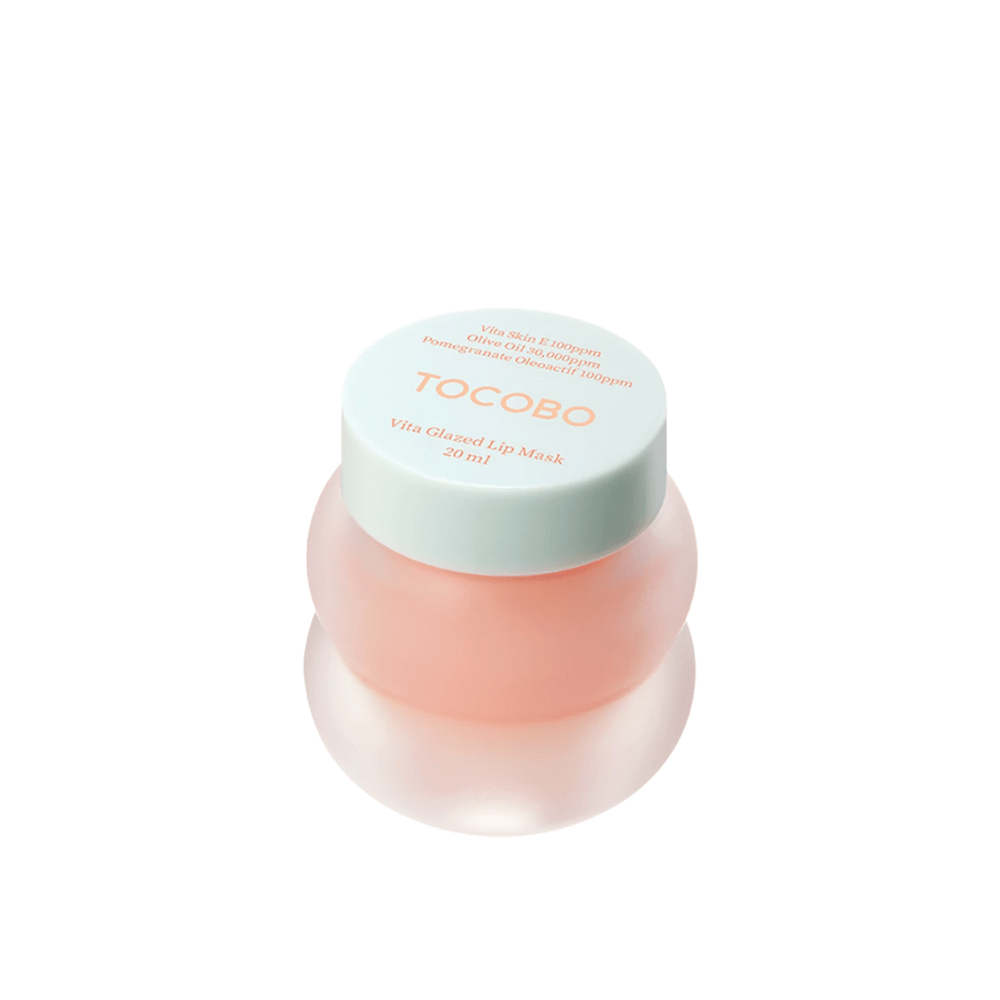 Un barattolo con "Vita Glazed Lip Mask" da Tocobo è mostrato. Il barattolo è rotondo e trasparente con un coperchio turchese chiaro. La maschera all'interno è di un rosa chiaro ed è progettata per idratare e curare le labbra. Il prodotto ha un volume di 20 ml.