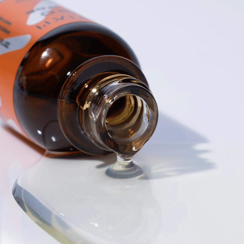 Primo piano di TIA'M Vita C Source-siero che scorre da una bottiglia di vetro marrone. La formula chiara del siero evidenzia il suo contenuto concentrato di vitamina C per una pelle radiosa.
