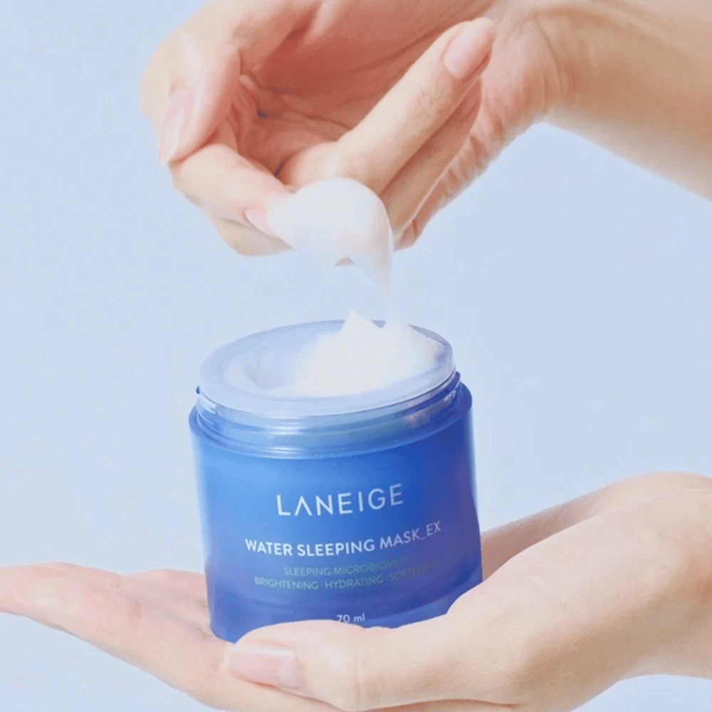 Una mano raccoglie LANEIGE Water Sleeping Mask da un barattolo blu, con messa a fuoco sulla consistenza simile a gelatina su sfondo azzurro.