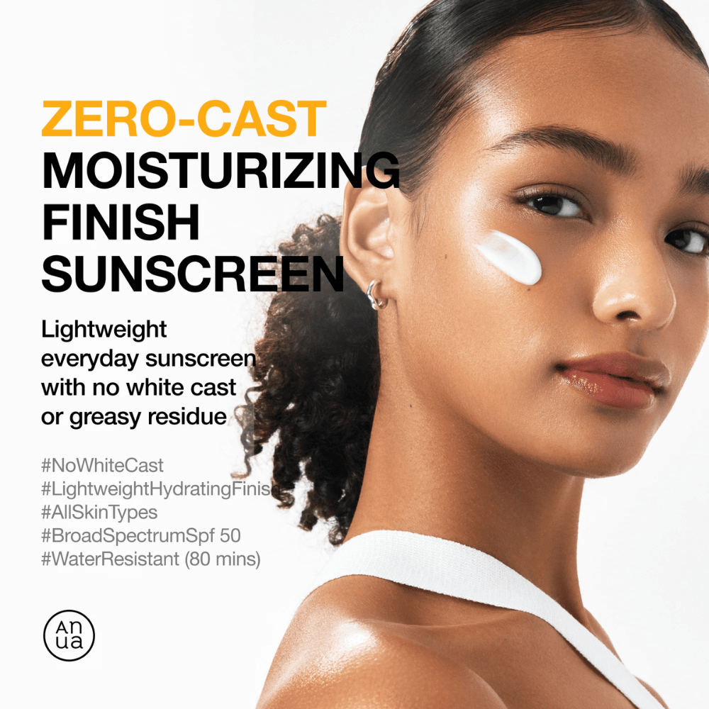 Donna con crema solare sulla guancia mostra ANUA Zero-Cast Moisturizing Finish Sunscreen – una crema solare leggera e idratante con SPF 50 che non lascia residui bianchi.