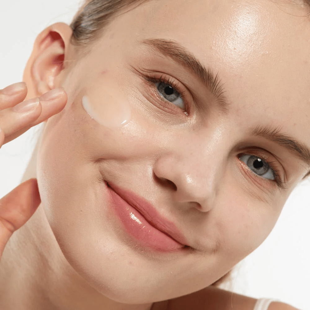 Modello che applica Medicube Zero Pore Serum 2.0 sulla guancia, un siero affinante per i pori che offre una struttura della pelle più uniforme, idratazione e una luminosità naturale.