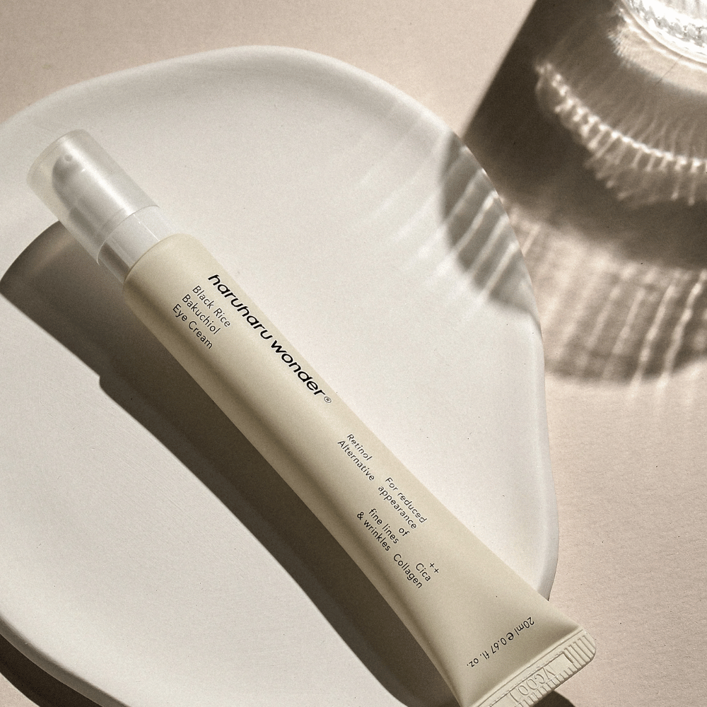 HaruHaru Wonder Black Rice Bakuchiol Eye Cream 20 ml – crema contorno occhi con riso nero, bakuchiol e collagene che riducono le linee sottili e le rughe, posizionato su un piatto di ceramica in luce soffusa.