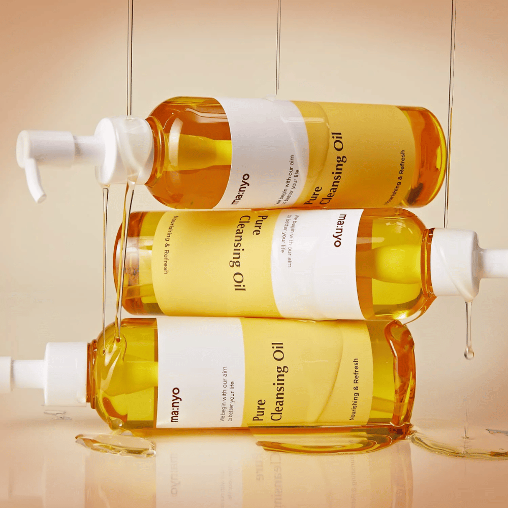 Tre bottiglie ma:nyo Pure Cleansing Oil 200ml impilate per la cura della pelle e la rimozione del trucco.