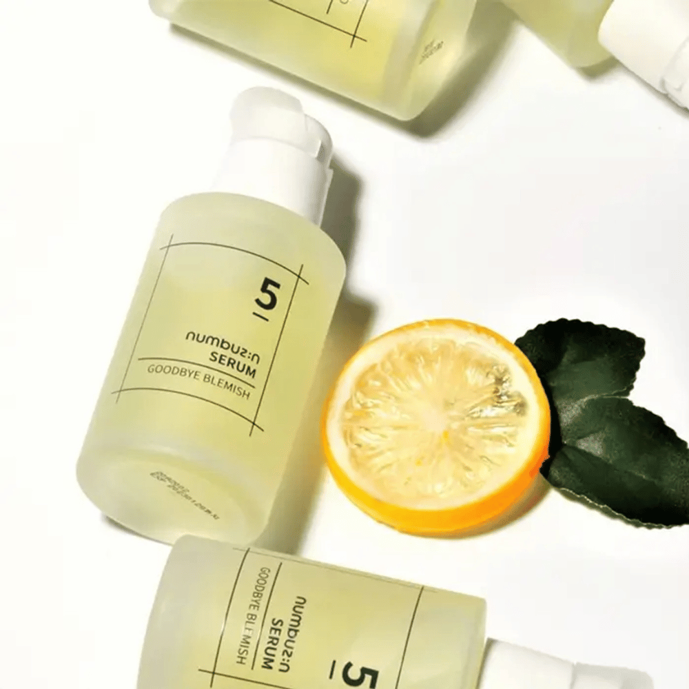 Cinque bottiglie numbuzin No.5 Goodbye Blemish Serum 50ml con limoni e foglie che si rivolgono a macchie e cicatrici da acne.
