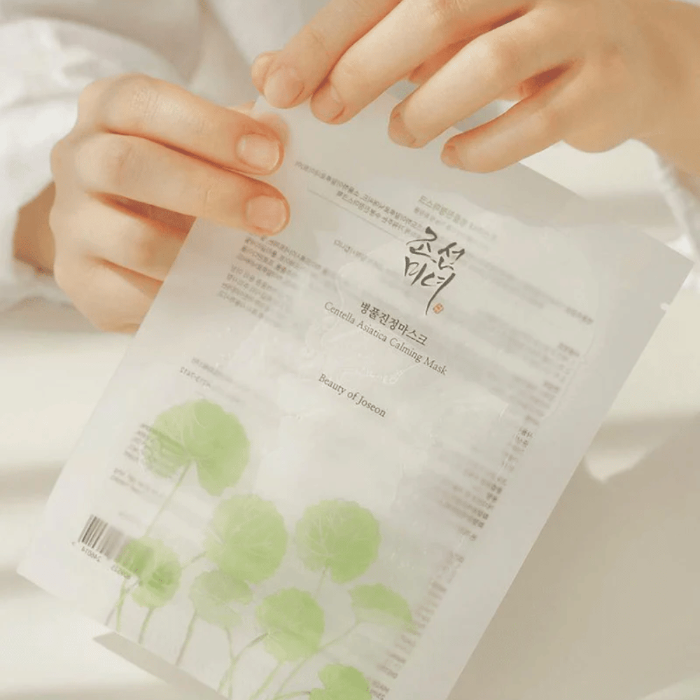 Una persona che tiene un foglio di carta con un Beauty of Joseon Centella Asiatica Calming Mask 1 st sopra.