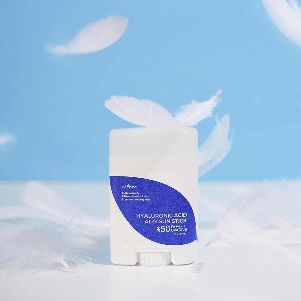 Un Isntree Hyaluronic Acid Airy Sun Stick con SPF 50+ e Acido Ialuronico, decorato con piume bianche.