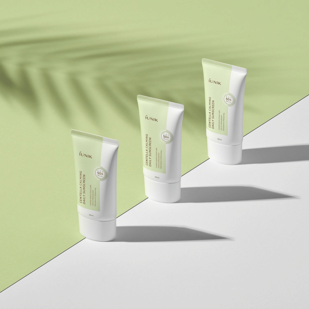 Tre tubi iUNIK Centella Calming Daily Sunscreen con SPF 50+ protezione contro i raggi UVA e UVB su sfondo bianco.